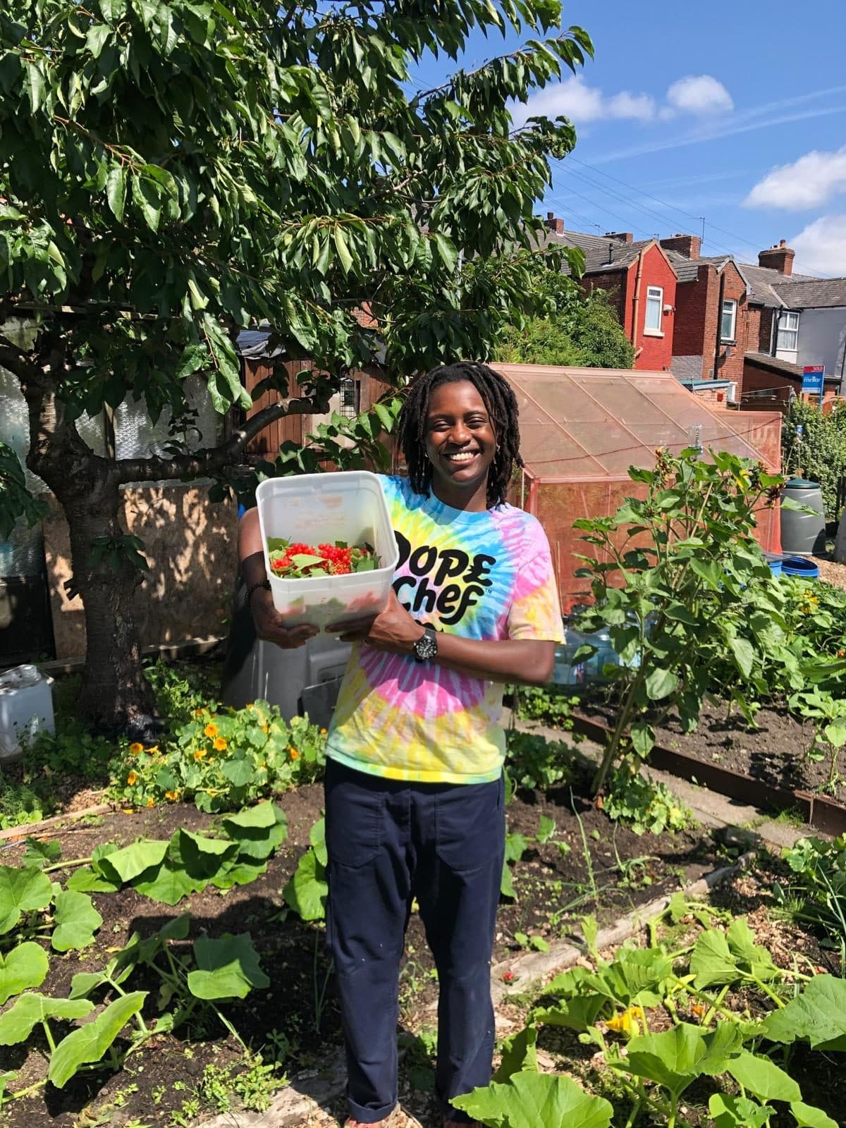 Ngwafu in her allotment, proudly presenting box of vegetables she has grown there